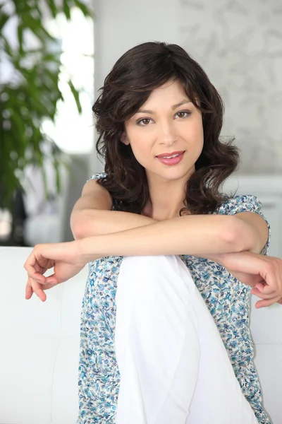 Confident woman sitting on a sofa — Stock Photo, Image