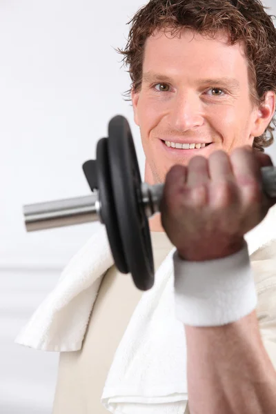 Young man doing exercises with a dumbbell — Stock Photo, Image