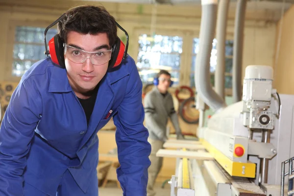 Apprentice working in a factory — Stock Photo, Image