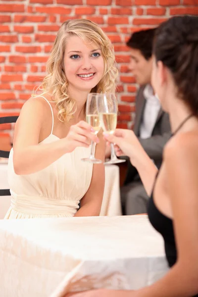 Девушки пьют шампанское в ресторане — стоковое фото