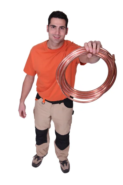 Trabalhador segurando tubo de cobre — Fotografia de Stock