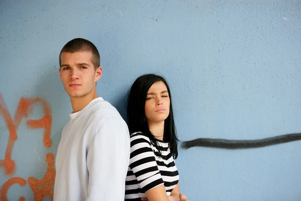 Two trendy teenagers stood against gratified wall — Stock Photo, Image