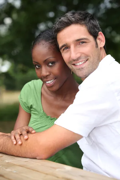Una pareja interracial en un parque . — Foto de Stock