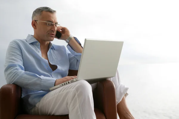 Uomo rilassato con un computer portatile e telefono — Foto Stock