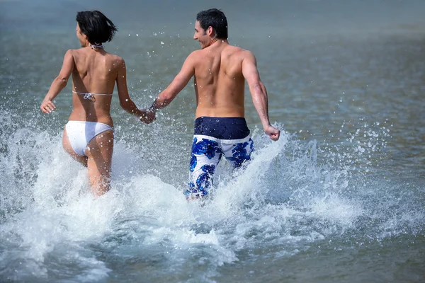 Couple running in the sea — Stock Photo, Image