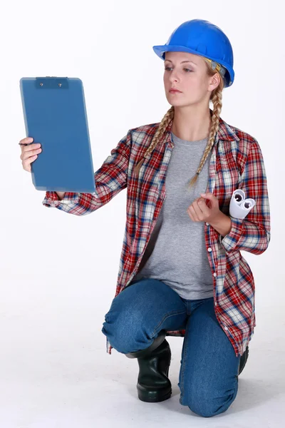 Tradeswoman looking at her clipboard — Stock Photo, Image