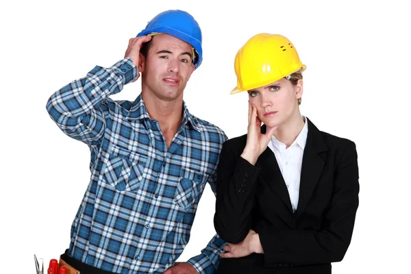 Female architect looking annoyed and foreman by her side — Stock Photo, Image