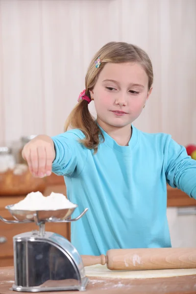 Child weighing flour on a scale — Stock Photo, Image