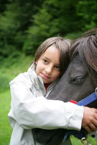 Ребенок гладит лошадь — стоковое фото
