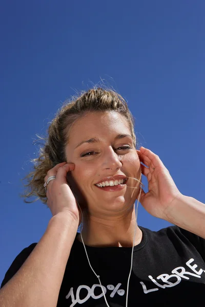 Blond kvinna lyssna på musik i solen — Stockfoto
