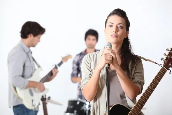 A guitar player, a drummer and a female singer — Stock Photo, Image