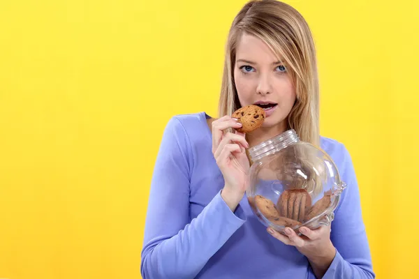 Schattige blonde eten cookies. — Stockfoto