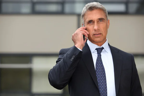Mature businessman using a cell phone — Stock Photo, Image