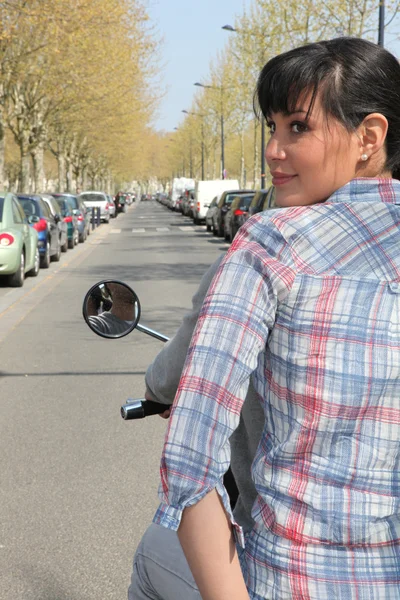 Mujer joven montando pillion en un scooter —  Fotos de Stock