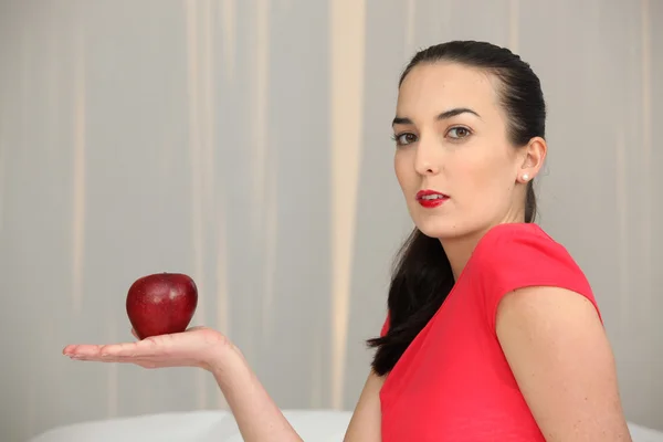 Vrouw met een rode appel in de palm van haar hand — Stockfoto