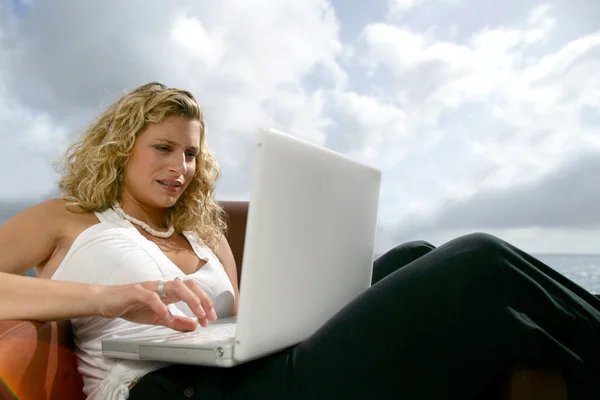 女人坐在海边用的笔记本电脑 — 图库照片
