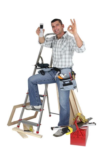Telefon aracılığıyla tüm açık alırken marangoz — Stok fotoğraf