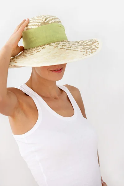 恥ずかしがり屋の女性の顔の上に帽子を押す — ストック写真