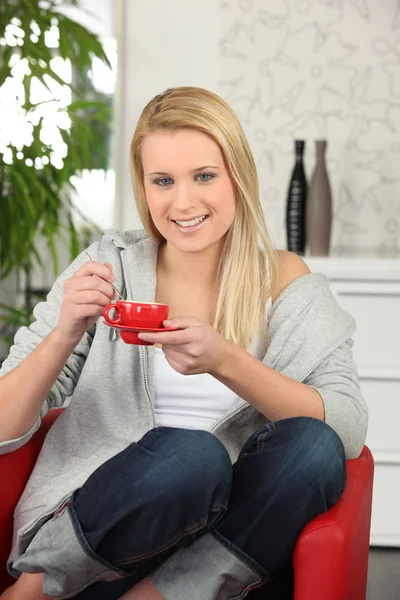 Молода жінка має чашку кави вдома — стокове фото
