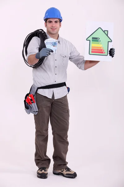 Tradesman holding a wad of money and an energy efficiency rating sign — Stock Photo, Image