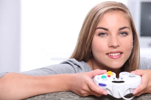 Блондинка, играющая в видеоигры с блокнотом — стоковое фото