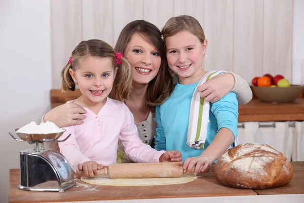 Мать и дочери пекут хлеб — стоковое фото