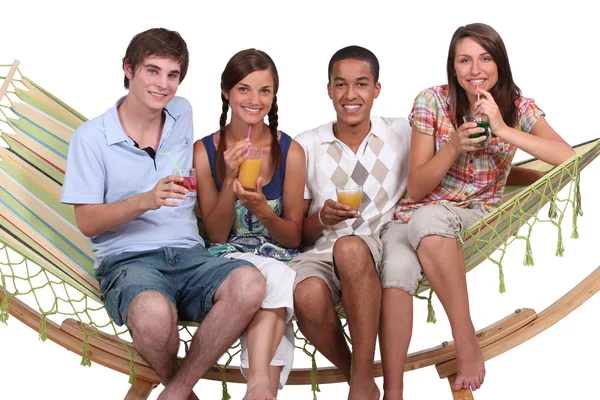 Amigos bebiendo cócteles en una hamaca — Foto de Stock