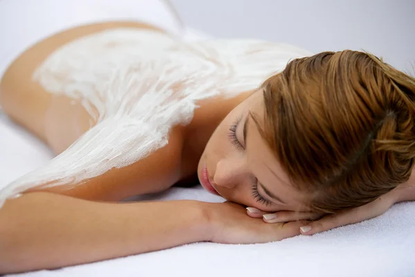 Young woman laid with cream on her back — Stock Photo, Image
