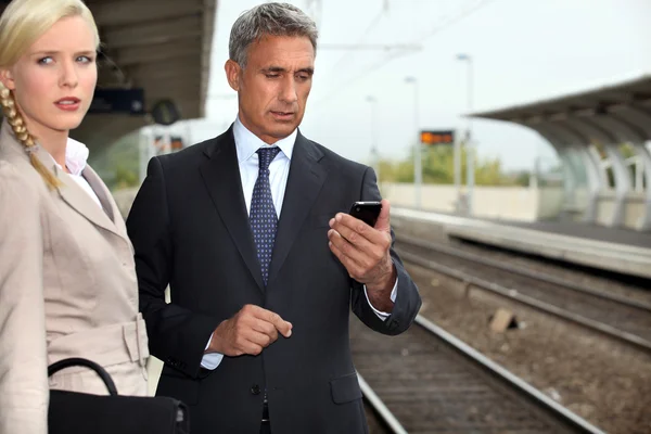 Business par väntar på ett tåg — Stockfoto