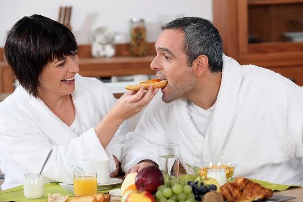 Playful couple having breakfast — Stock Photo, Image