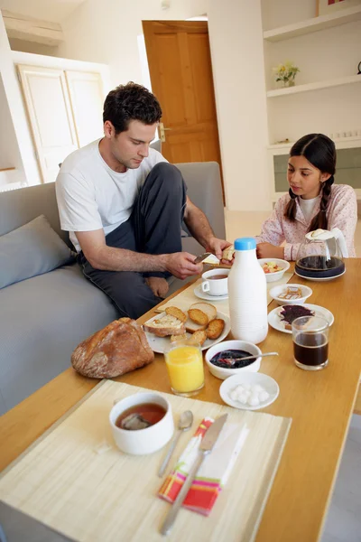 Par med frukost i vardagsrummet — Stockfoto