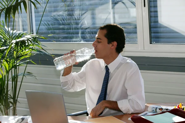 Бизнесмен пьет из большой бутылки воды — стоковое фото