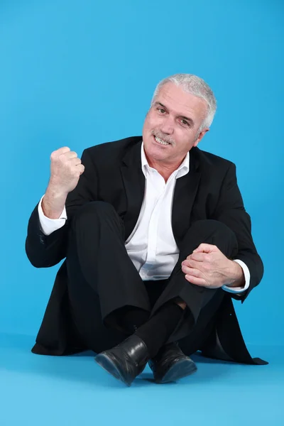 An angry man sitting cross-legged — Zdjęcie stockowe