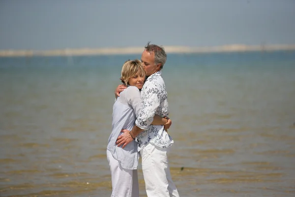 Ein Paar, das sich am Wasser umarmt — Stockfoto
