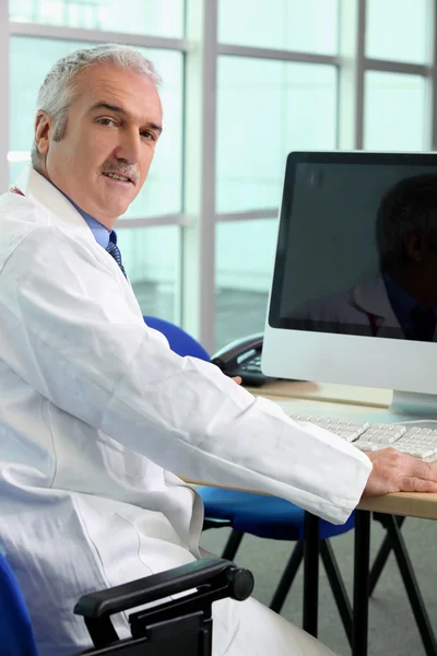 Doktor seděl u počítače — Stock fotografie