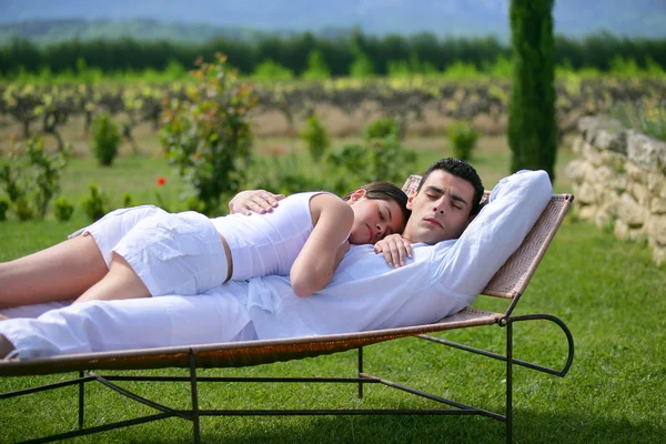 Couple having a nap on sun lounger — Stock Photo, Image