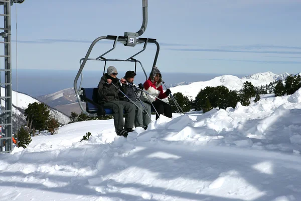 Three sitting in a ski lift — Stock Photo, Image