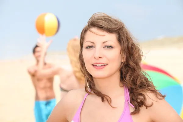 Teenager-Mädchen am Strand mit zwei Freunden im Hintergrund — Stockfoto