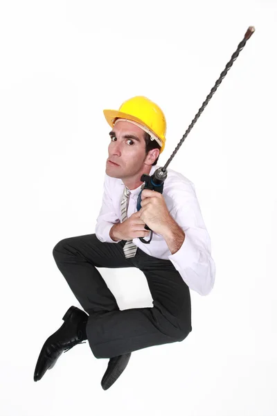 Businessman holding drill with long attachment — Stok fotoğraf