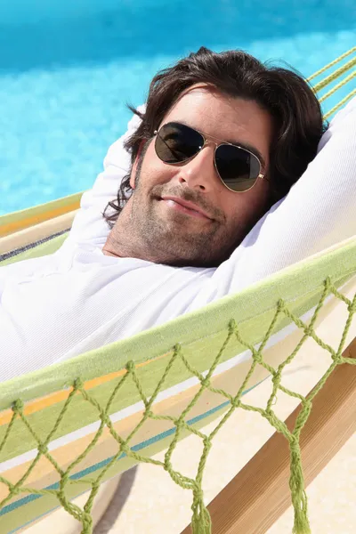 Hombre relajándose junto a la piscina — Foto de Stock