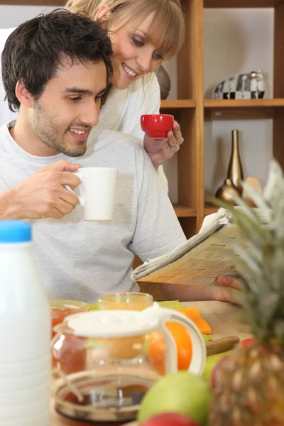 朝食を食べながら新聞を読んでカップル — ストック写真