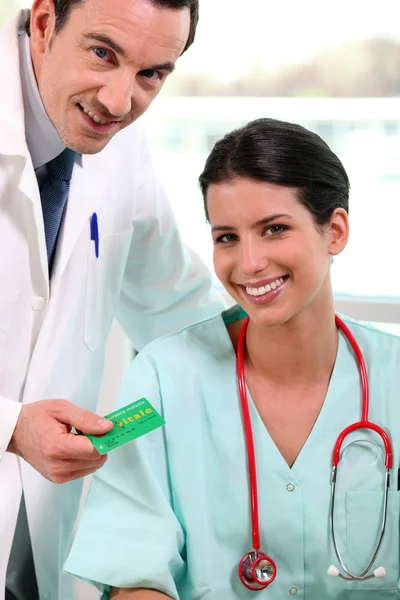 Läkare och sköterska tar hand om patientens sjukförsäkring — Stockfoto