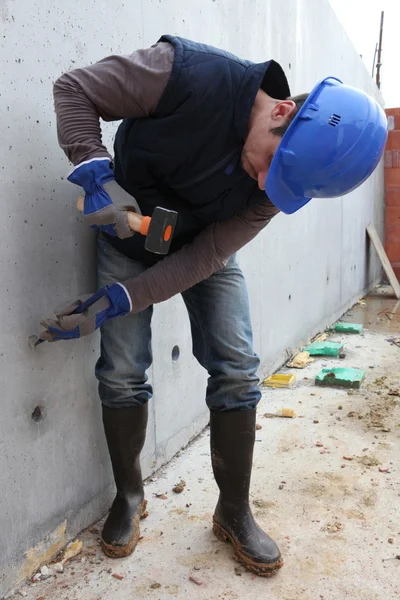 Artigiano che fa un buco nel muro — Foto Stock