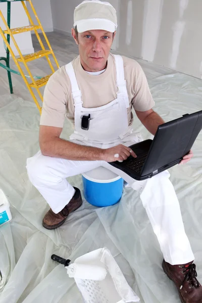 Maler saß mit Laptop auf Leiter — Stockfoto