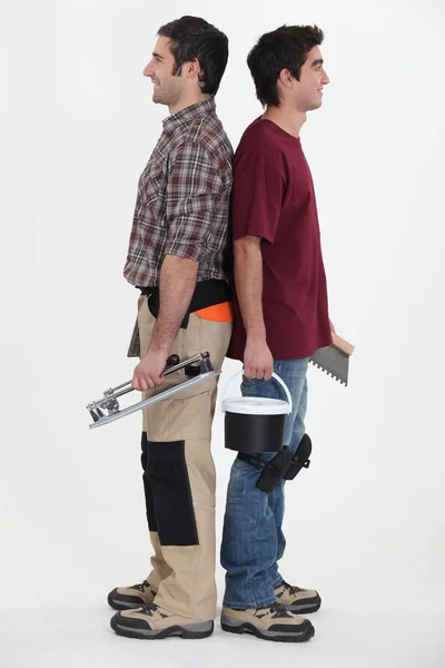 Handwerker und Lehrling stehen Rücken an Rücken — Stockfoto