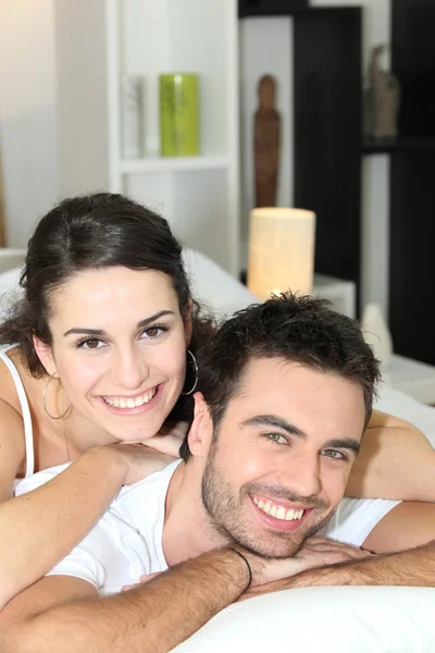 Veselý mladý pár v posteli — Stock fotografie