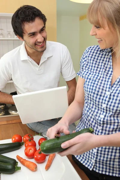 Coppia che prepara un pasto con l'aiuto di una ricetta su internet — Foto Stock