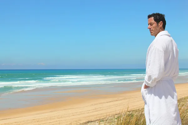 Man in badjas op het strand — Stockfoto