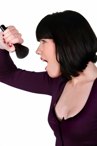 Mulher cantando em uma escova de maquiagem — Fotografia de Stock