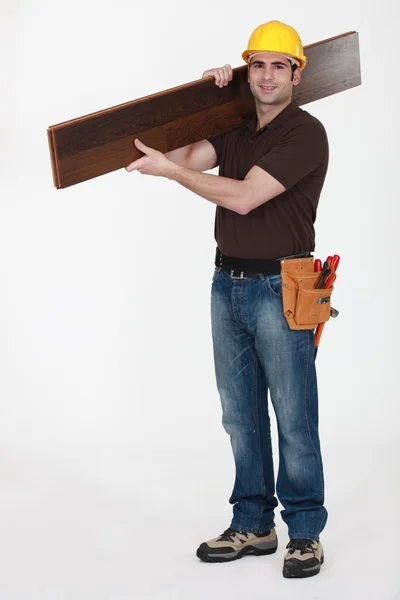 寄せ木張りの床を運ぶ男 — ストック写真